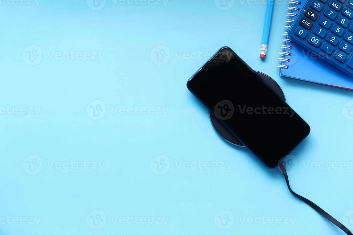 smartphone laddning på blå bakgrund foto