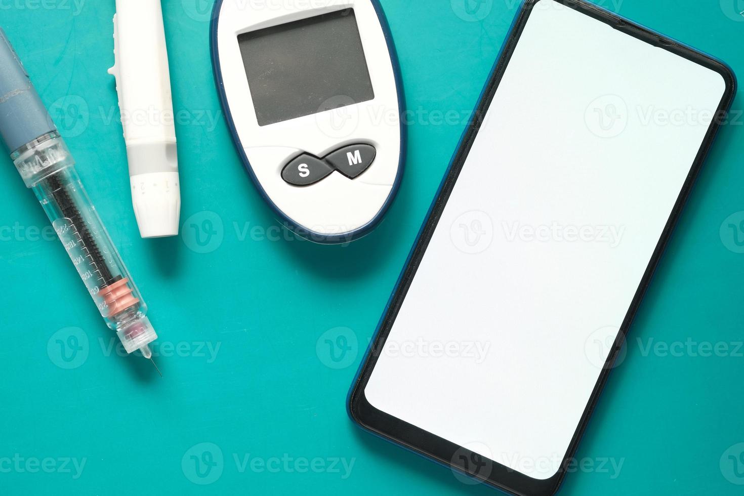 diabetiska mätverktyg, insulin och smart telefon på blå bakgrund foto