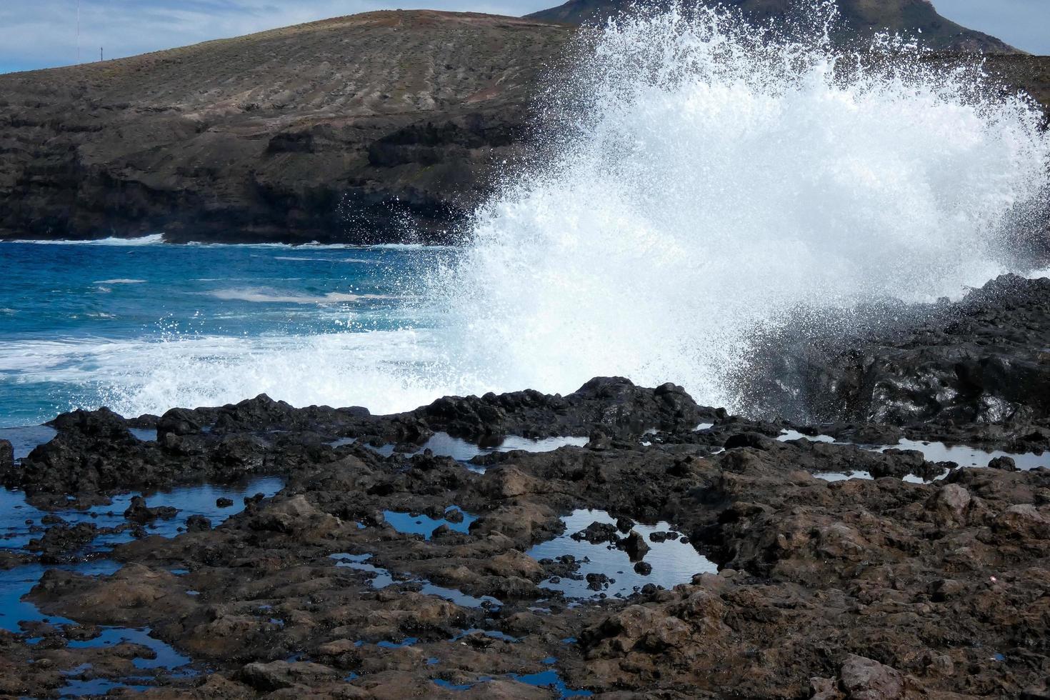 stor vågor kraschar mot de stenar i de hav foto