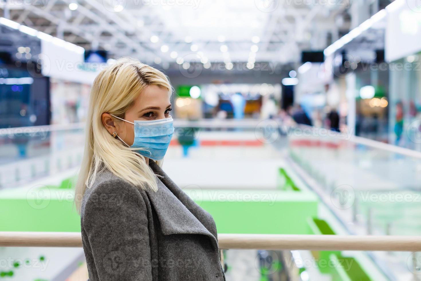 en ung kvinna bär en skyddande mask medan handla på de köpcenter. de begrepp av sjukdom hälsa och virus skydd. foto