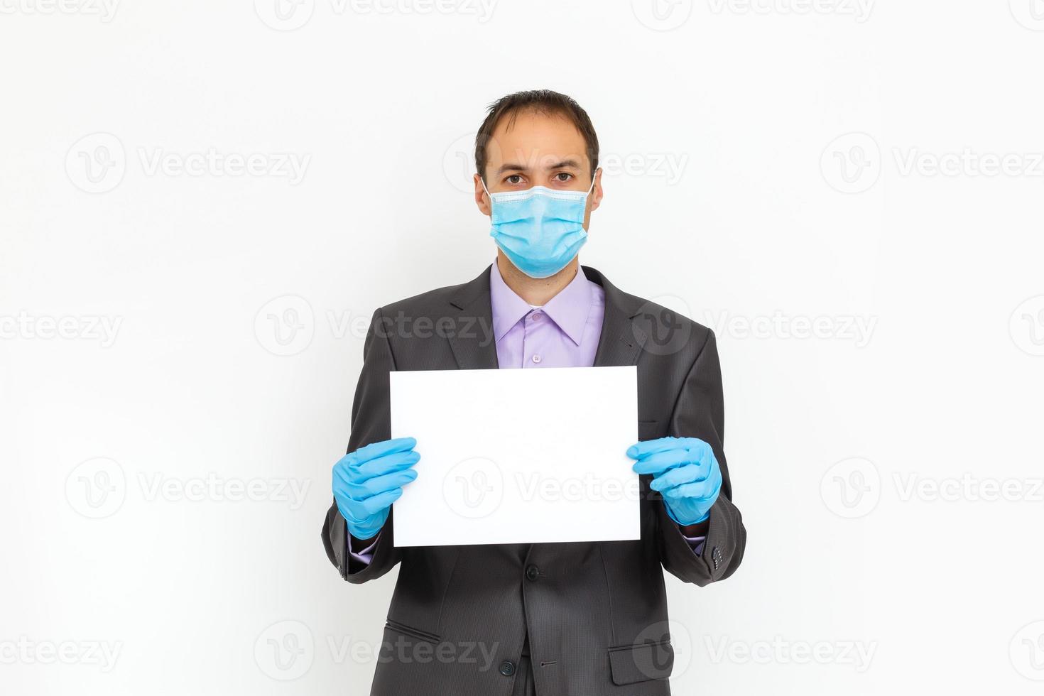 stänga upp av en affärsman i en kostym bär skyddande ansikte mask, skaffa sig redo för coronavirus och pm 2.5 stridande mot grå bakgrund. sjukvård begrepp. foto