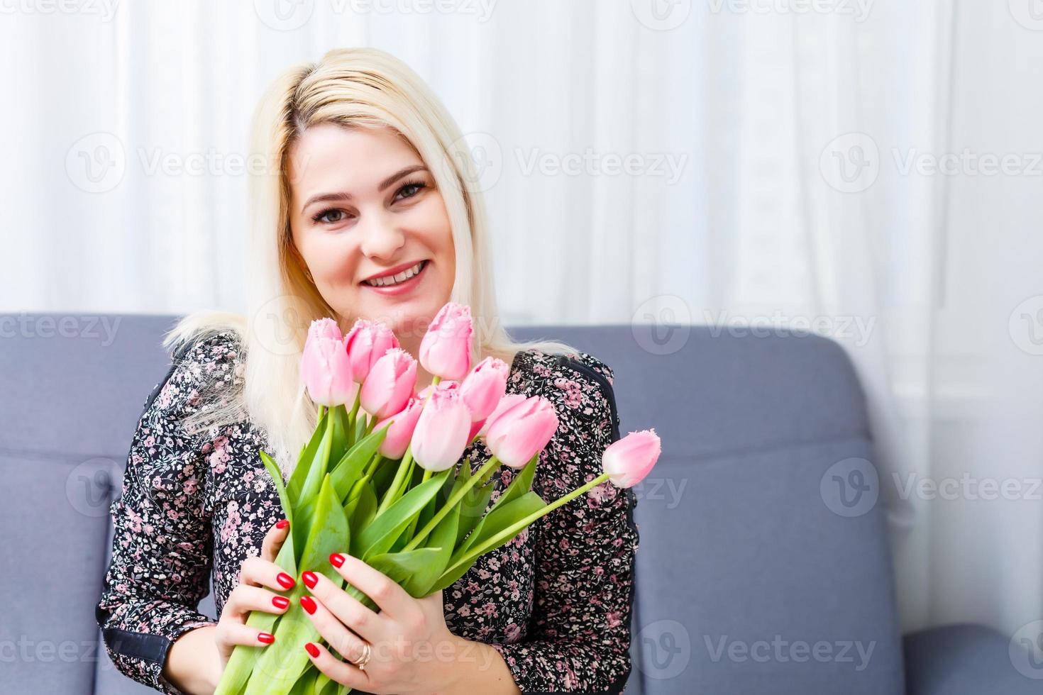 kvinna med vår blomma bukett. Lycklig överraskad modell kvinna lukta blommor. mors dag. springtime foto