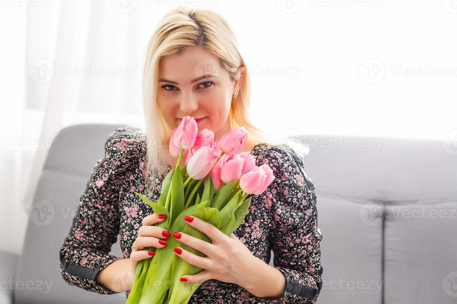 kvinna med vår blomma bukett. Lycklig överraskad modell kvinna lukta blommor. mors dag. springtime foto