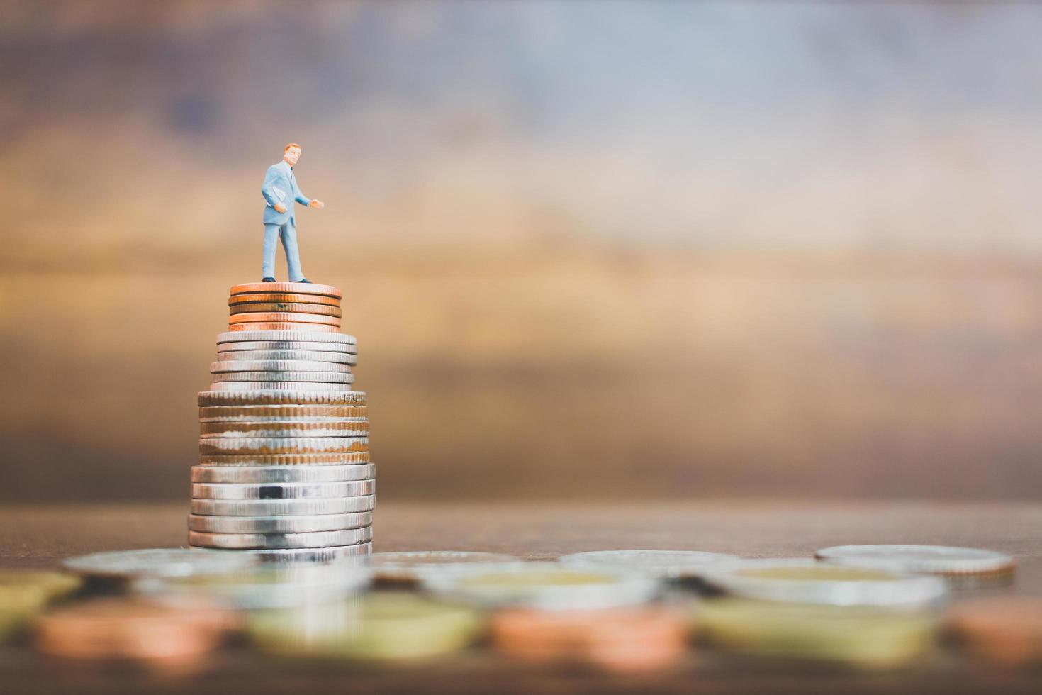 miniatyraffärsman som står på pengar med en träbakgrund foto
