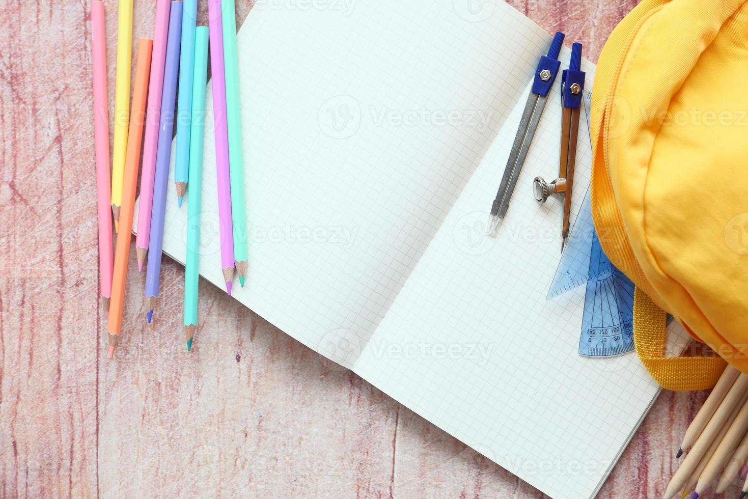 ovanifrån av gul ryggsäck med färgglada brevpapper på bordet foto