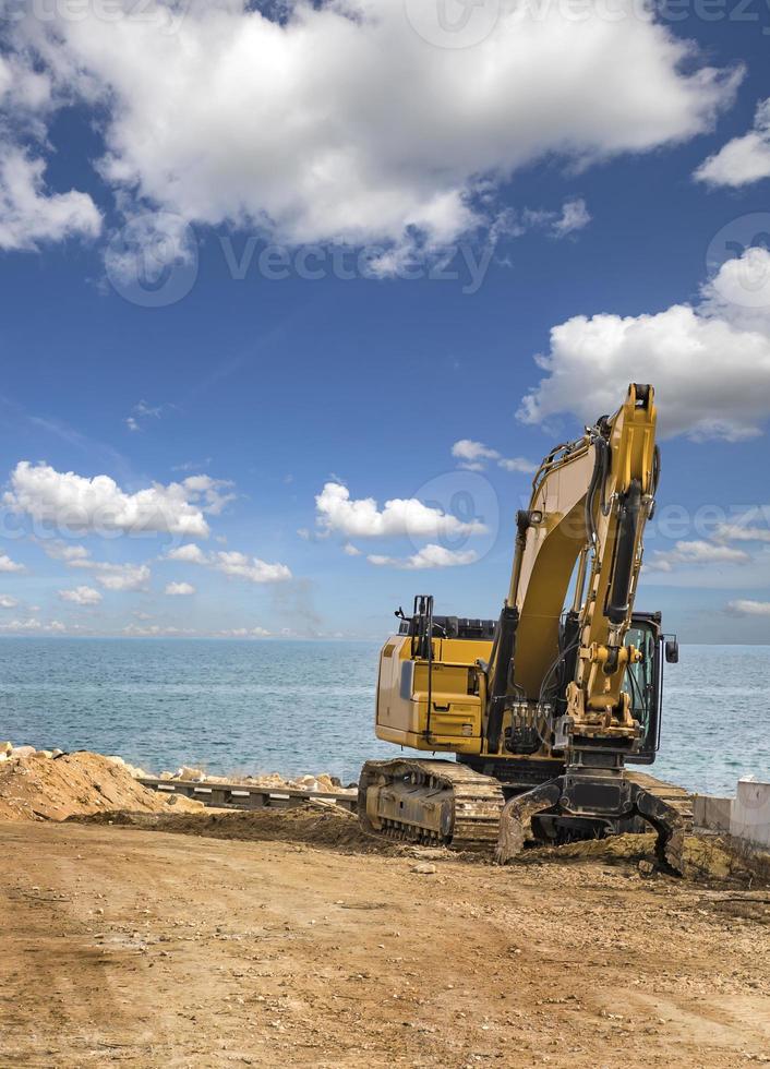 crawler grävmaskin efter Arbetar på de konstruktion webbplats på hav strand foto