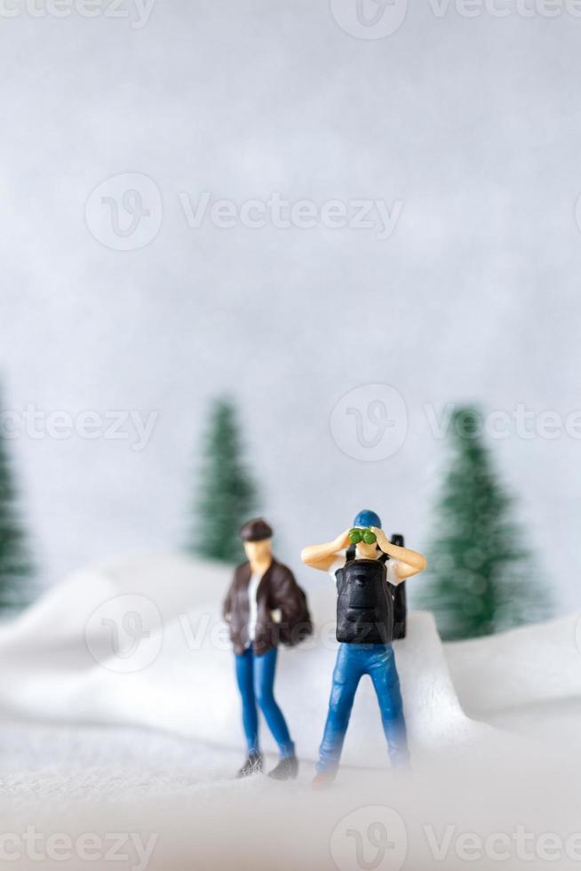 miniatyr- människor backpacker resa i vinter- tid foto