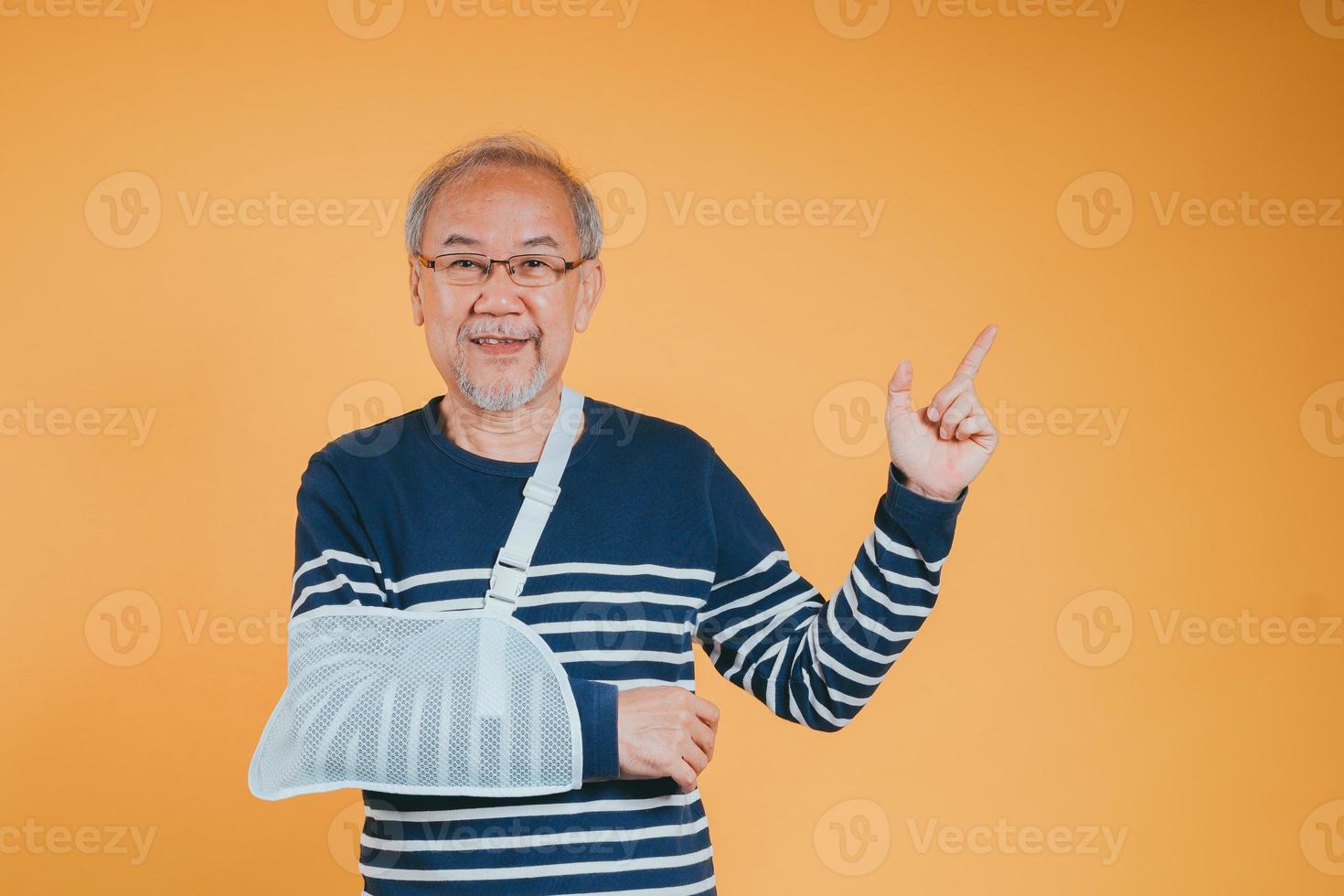 ärm bruten. senior manlig sling Stöd hand självsäker leende bruten efter olycka ha på sig ärm skena för behandling visa Bra tecken. hälsa försäkring på mobil begrepp. foto