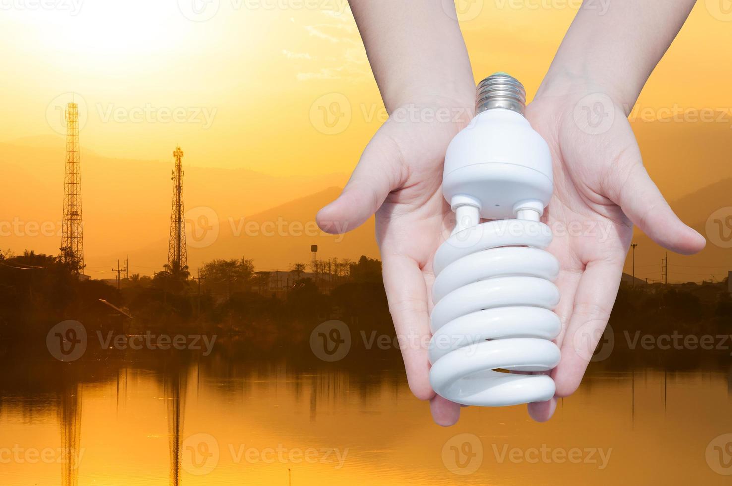 energi sparande begrepp, kvinna hand innehav ljus Glödlampa på industri landskap bakgrund, idéer ljus Glödlampa i de hand foto