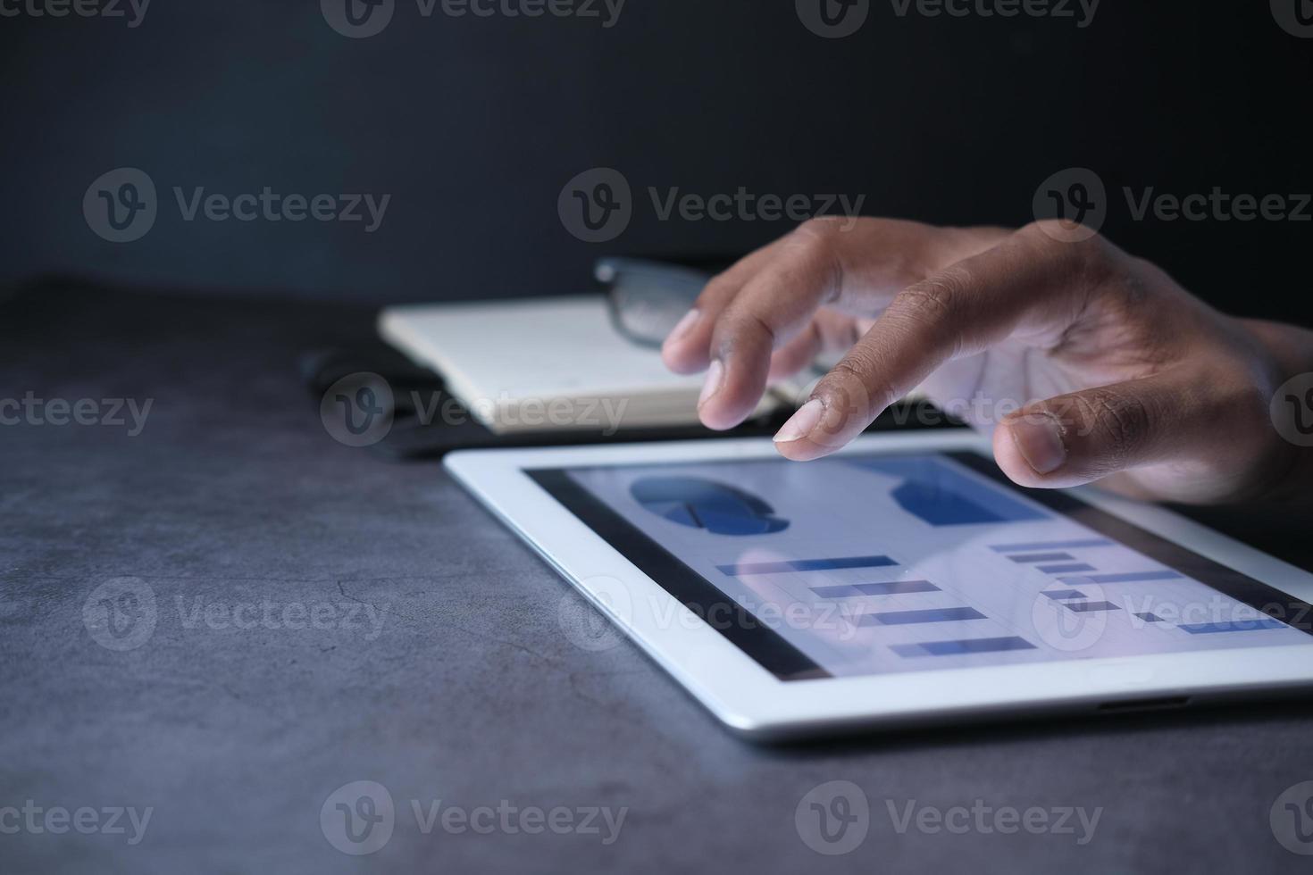 mans hand som arbetar på digital tablet vid kontorsskrivbordet foto