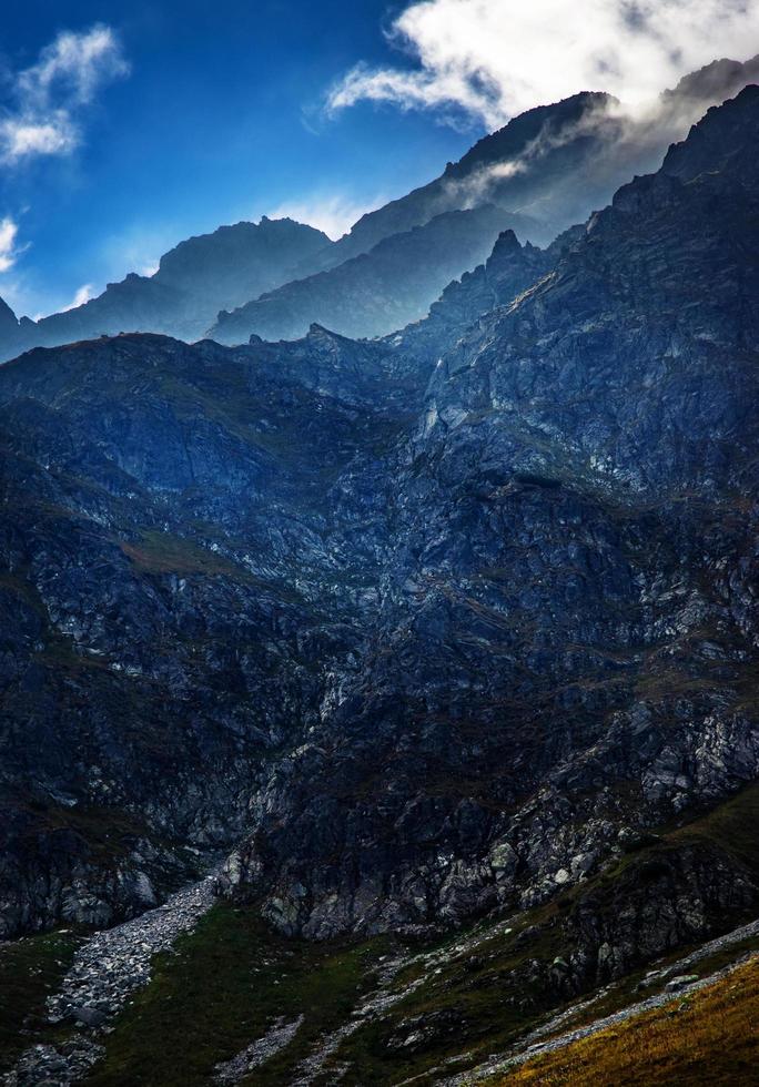 moln på toppen av de steniga bergen foto