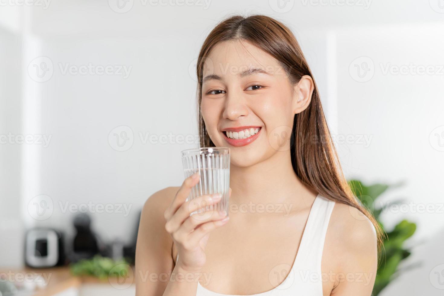 Lycklig skön, asiatisk ung kvinna, flicka dricka, smutta färsk glas av vatten för hydrat, innehav transparent glas i henne hand, törstig på Hem. hälsa vård, friska livsstil begrepp. foto