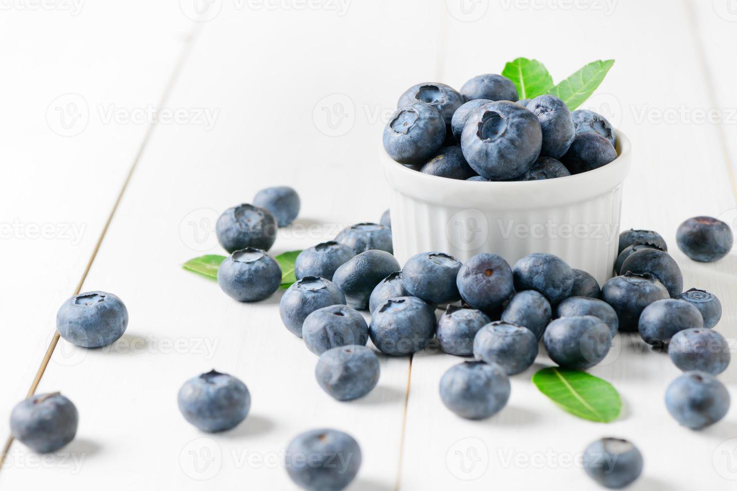 färsk blåbär frukt med blad på vit glas foto