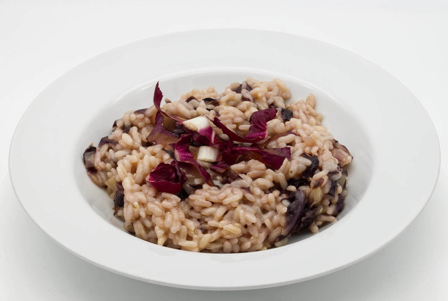 italiensk risotto al radicchio rosso, risotto med röd radicchio, i en vit maträtt foto