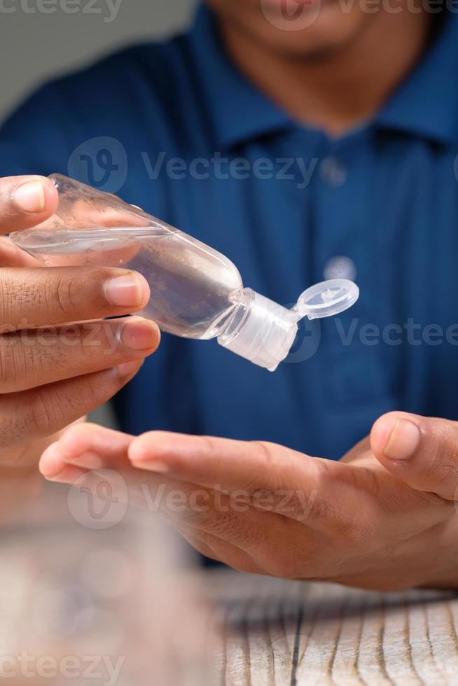 närbild av ung man använder hand sanitizer gel foto