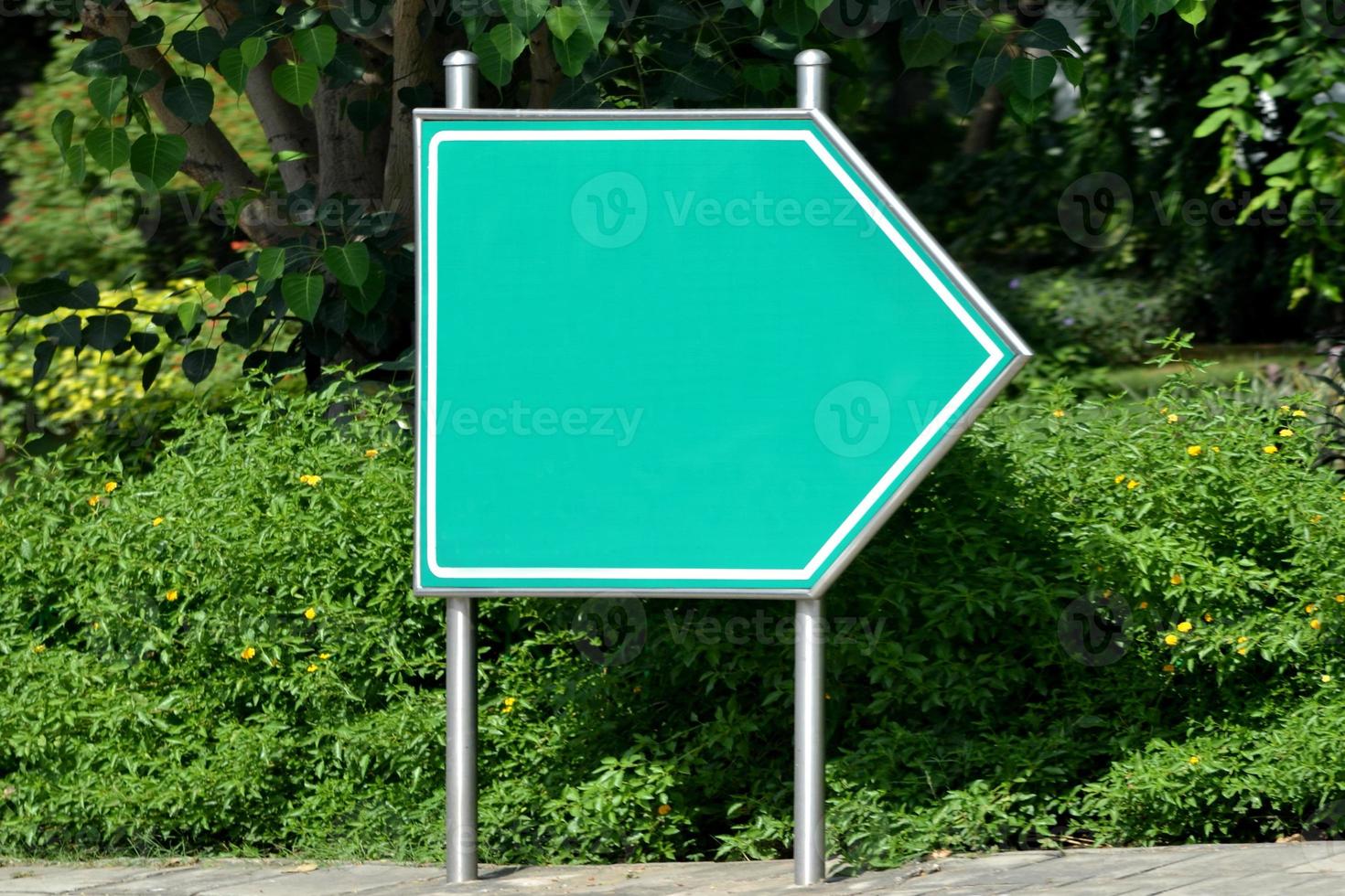 klar grön pil vägvisare på en gata foto