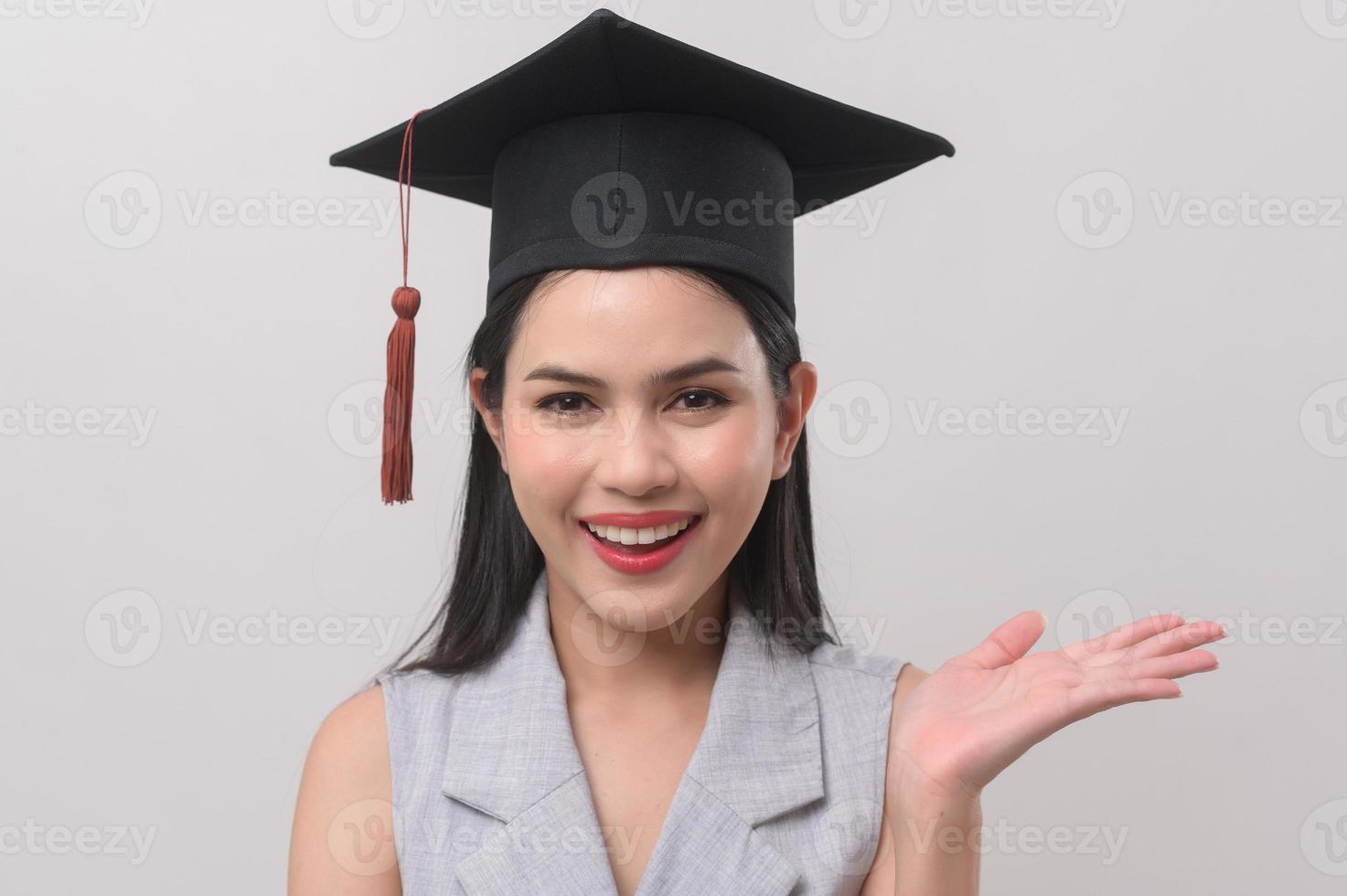 ung leende kvinna bär gradering hatt, utbildning och universitet begrepp foto