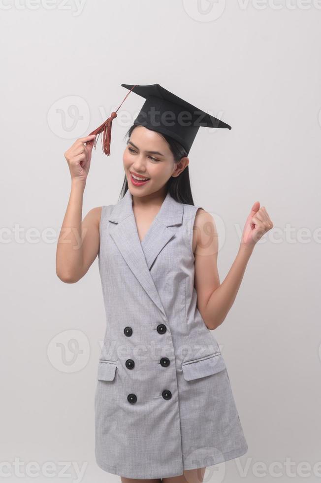 ung leende kvinna bär gradering hatt, utbildning och universitet begrepp foto