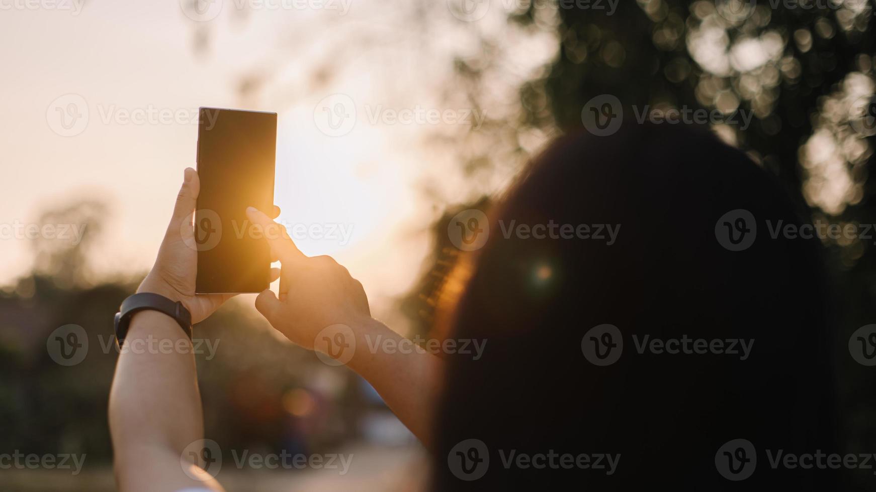 stänga upp kvinna hand håll använder sig av smart telefon på utomhus- parkera gata bakgrund. kopia Plats av teknologi företag och resa Semester begrepp. årgång tona filtrera effekt Färg stil. foto