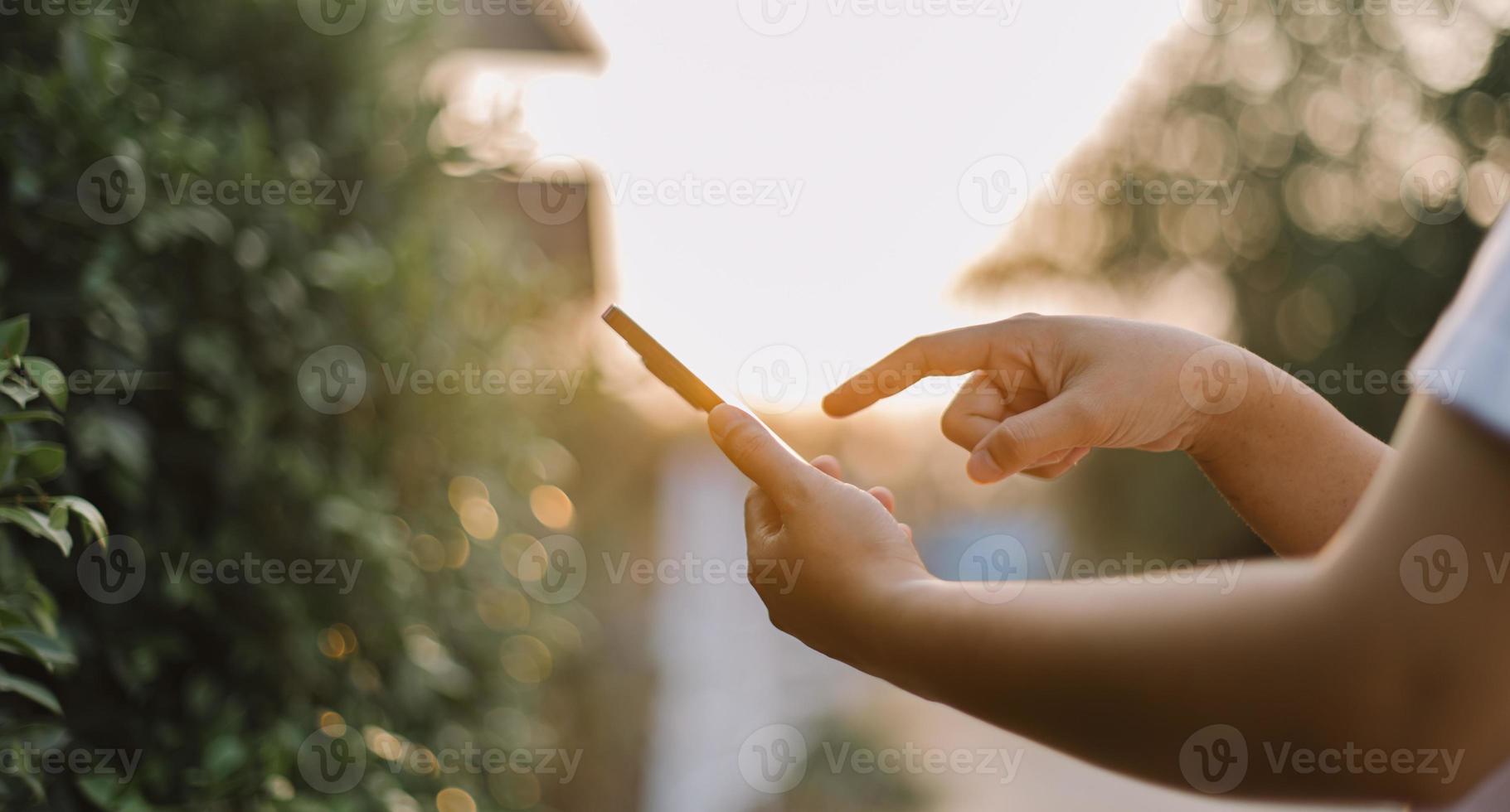 stänga upp kvinna hand håll använder sig av smart telefon på utomhus- parkera gata bakgrund. kopia Plats av teknologi företag och resa Semester begrepp. årgång tona filtrera effekt Färg stil. foto