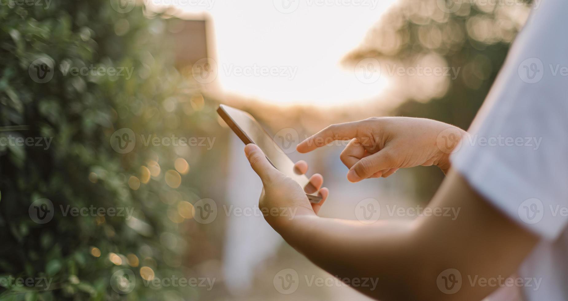 stänga upp kvinna hand håll använder sig av smart telefon på utomhus- parkera gata bakgrund. kopia Plats av teknologi företag och resa Semester begrepp. årgång tona filtrera effekt Färg stil. foto