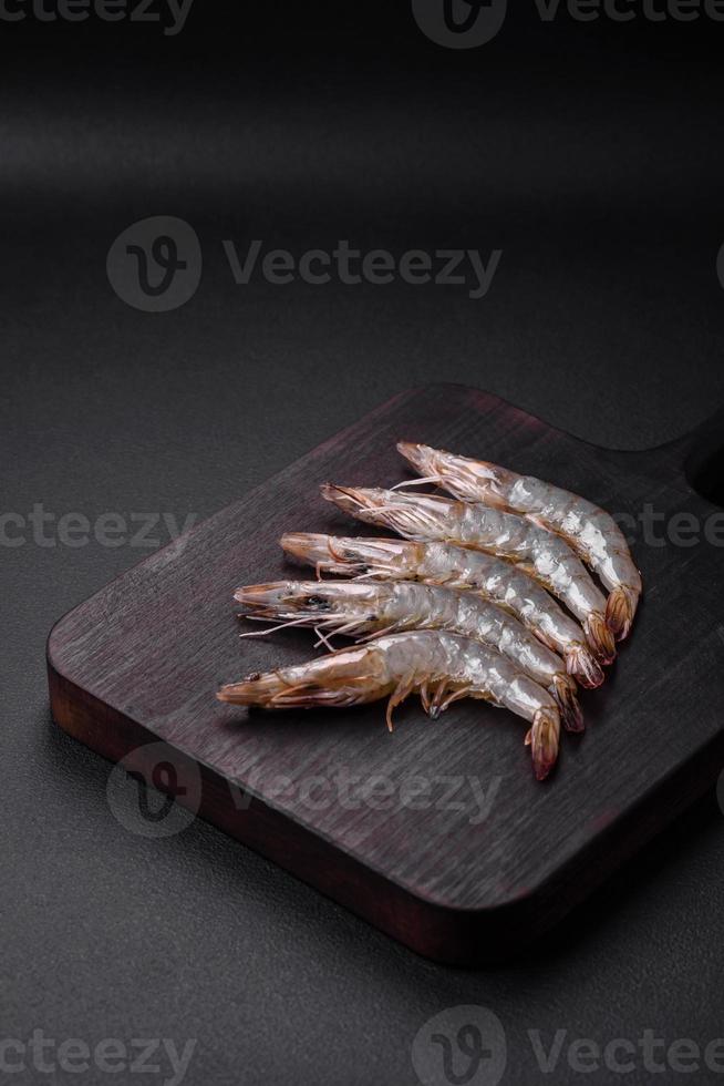 tiger räka eller havskräfta rå med kryddor och salt på en trä- skärande styrelse foto