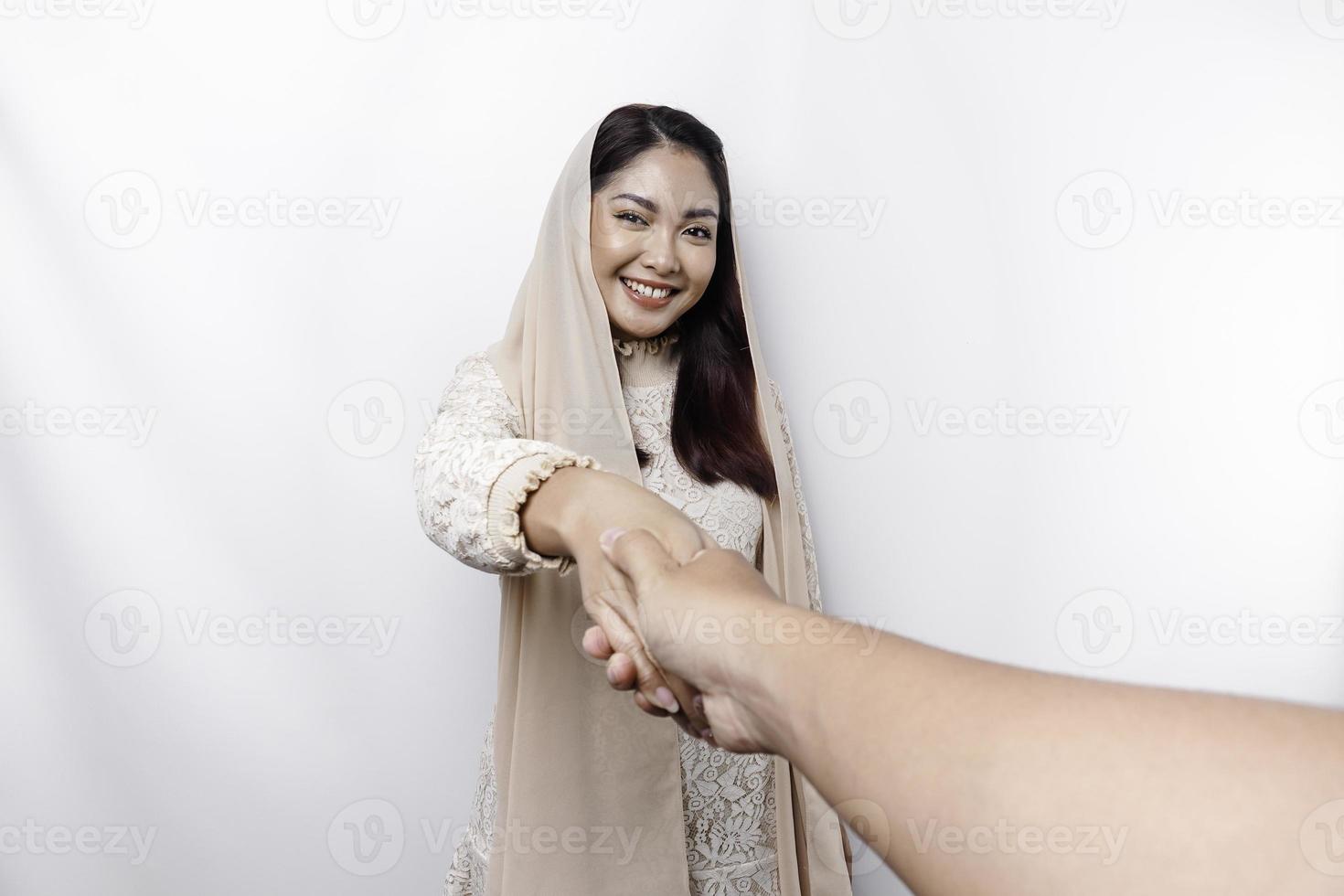 porträtt av en ung skön asiatisk muslim kvinna bär en slöja gestikulerar eid mubarak hälsning foto