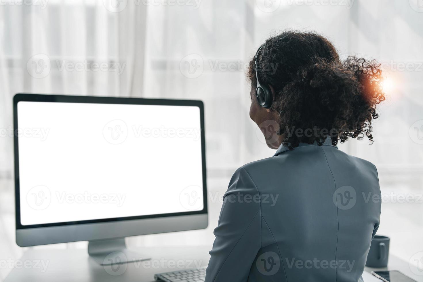 stänga upp ring upp Centrum operatör i trådlös headsetet talande med kund, kvinna i hörlurar med mikrofon hört klient på telefon i kund Stöd service, ser på dator skärm foto