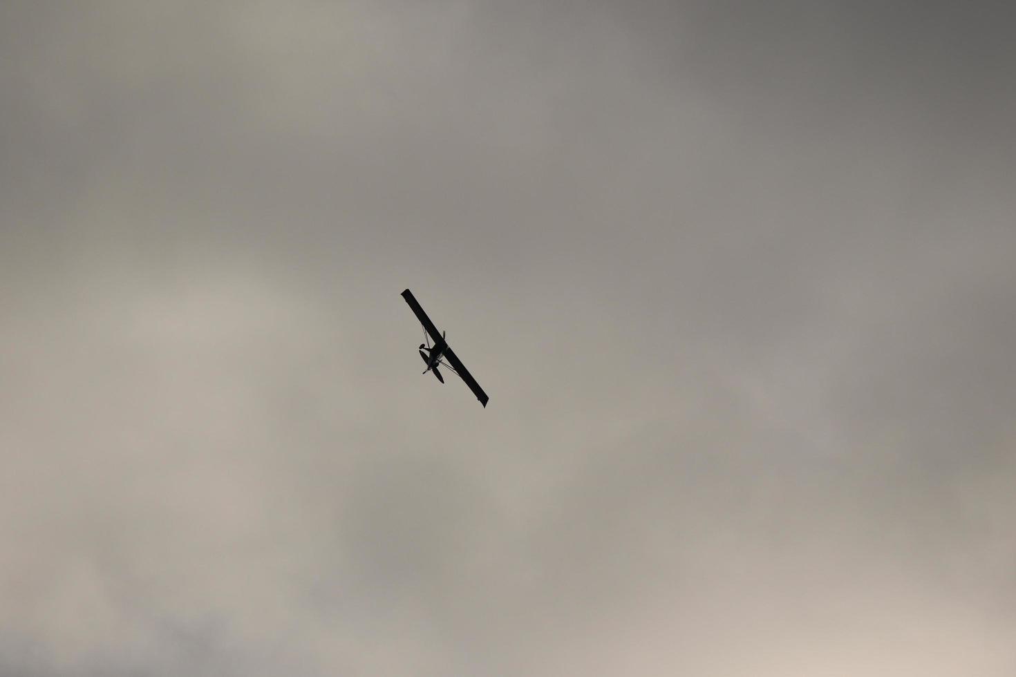 små plan flygande i de himmel mot mörk moln foto