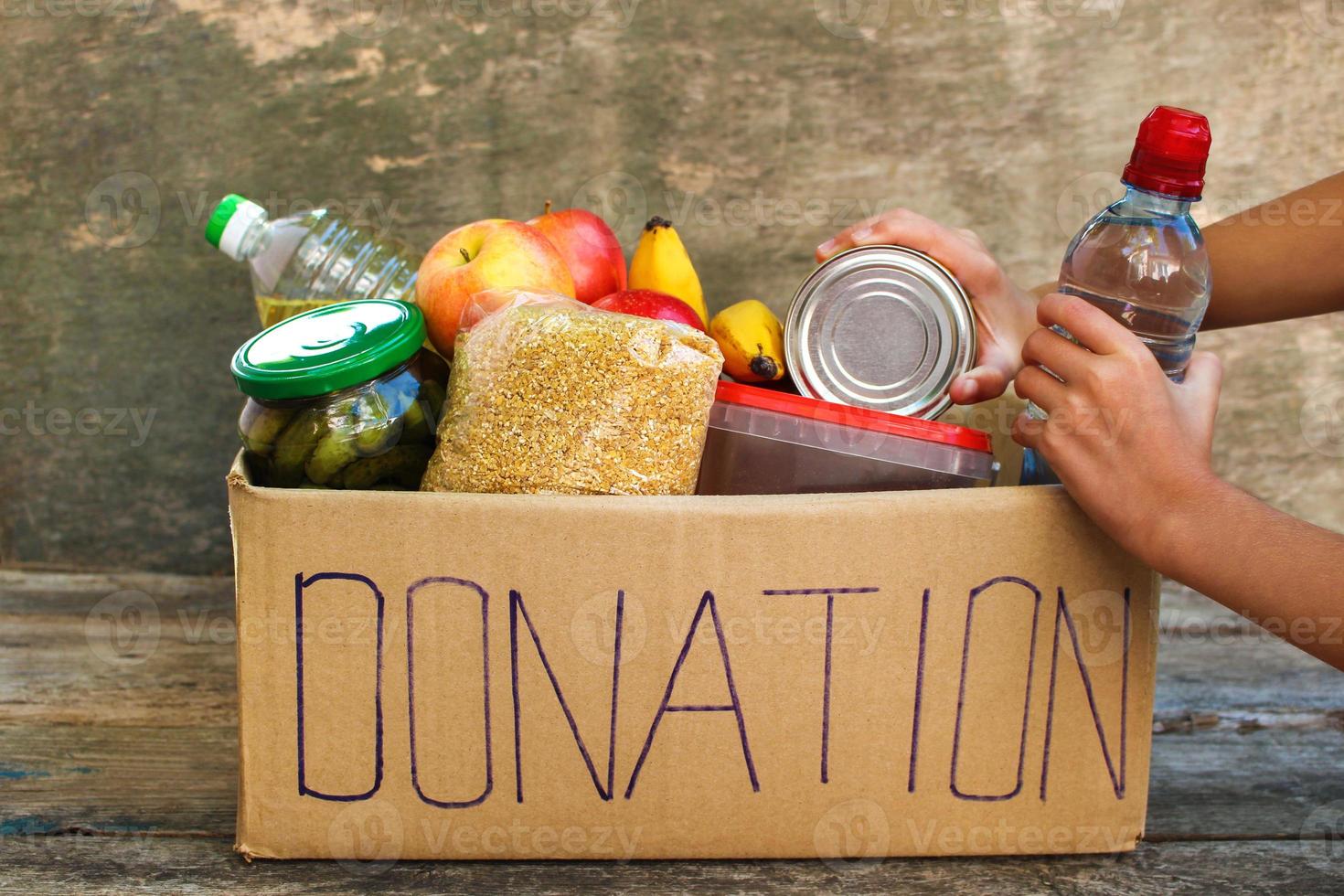 donation låda med mat på gammal trä- bakgrund. foto
