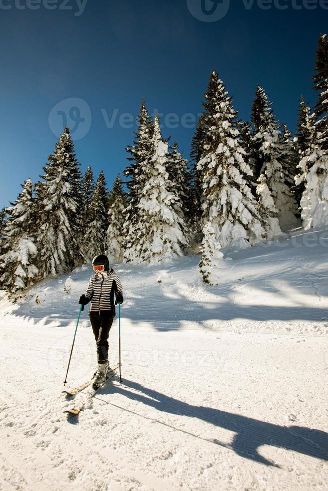 ung kvinna enjoing vinter- dag av skidåkning roligt i de snö foto