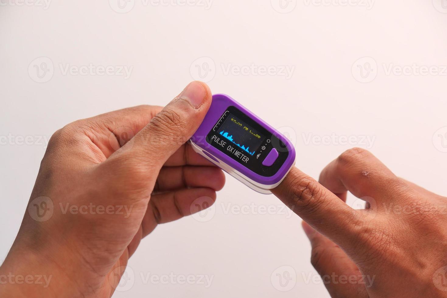 ung mans hand med pulsoximeter foto