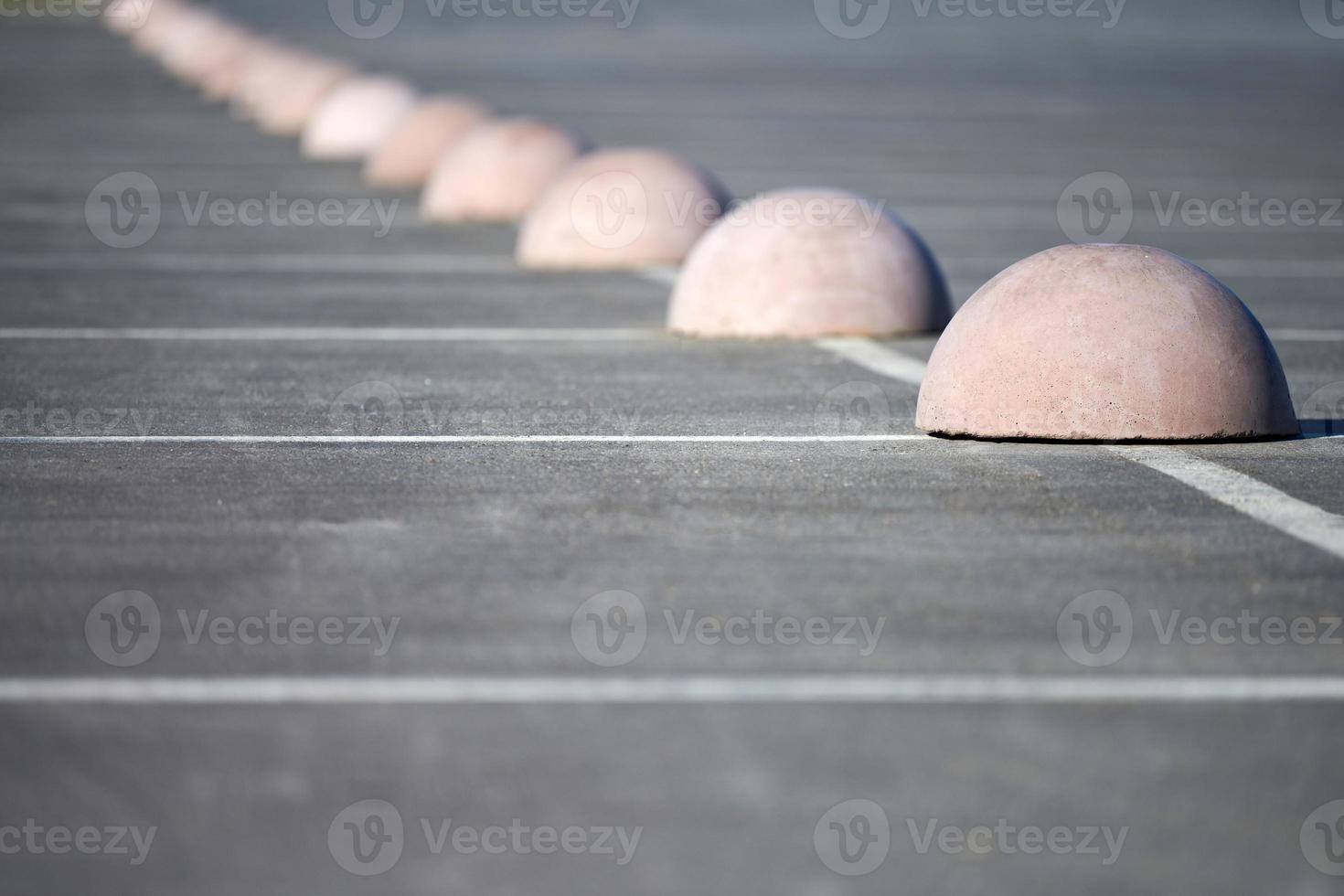 betong halvklot parkering begränsare. skydd från bil parkering. element till begränsa tillgång till parkering zon och kontrollera rörelse av fordon foto