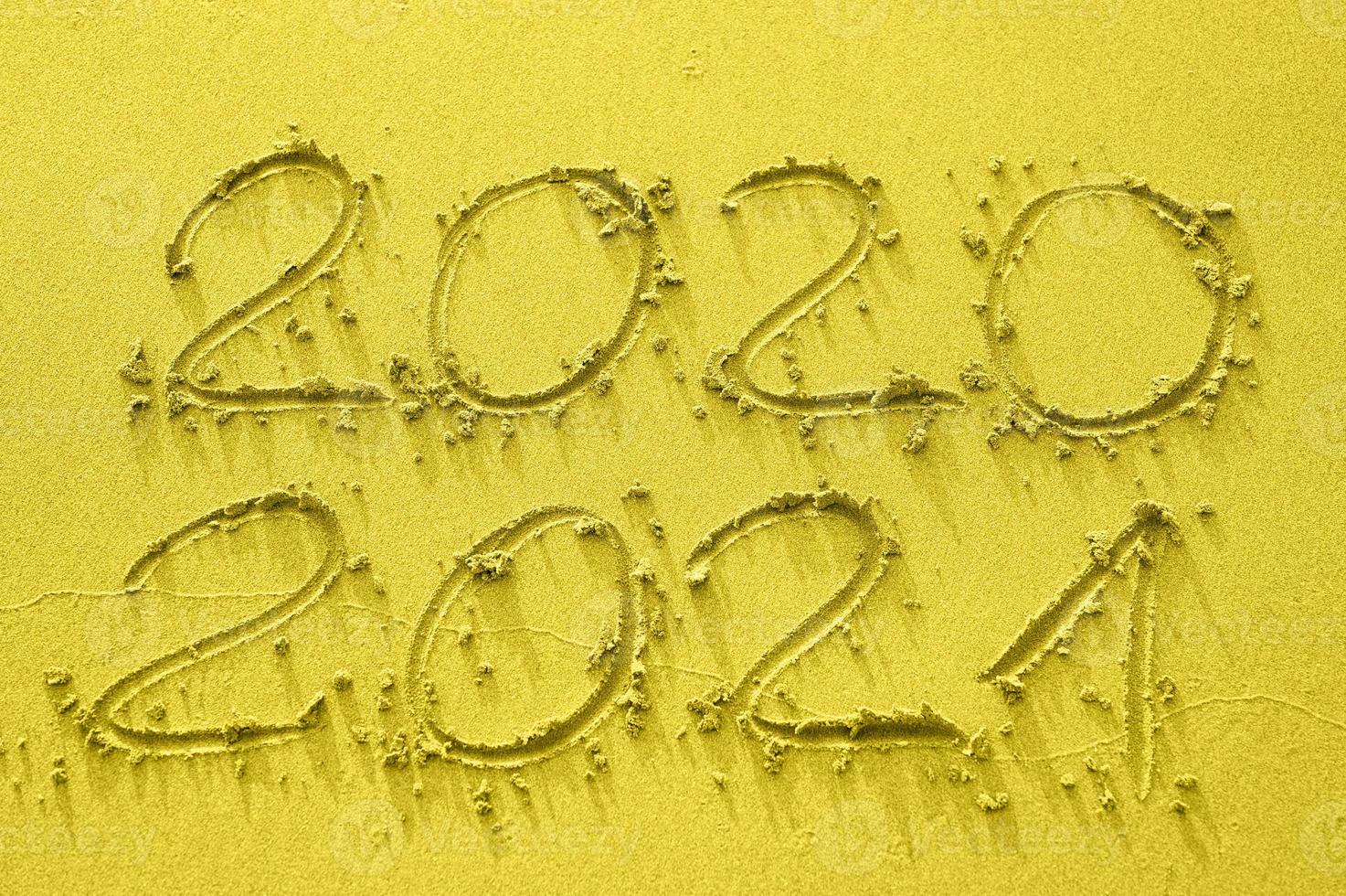 inskrift på guldsanden 2020 och 2021, tonad i trendfärgen år 2021 foto