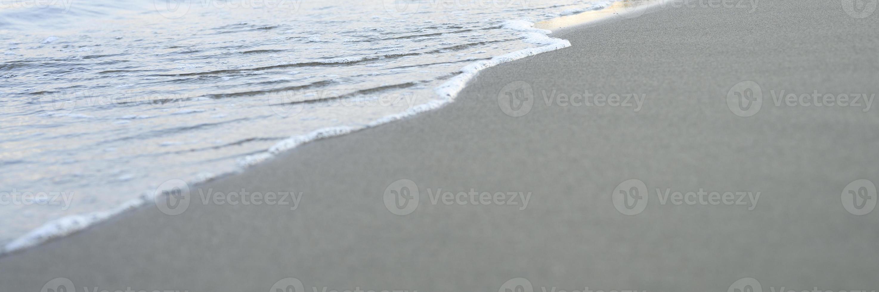 suddig våg av havet på kvällen sandstranden foto