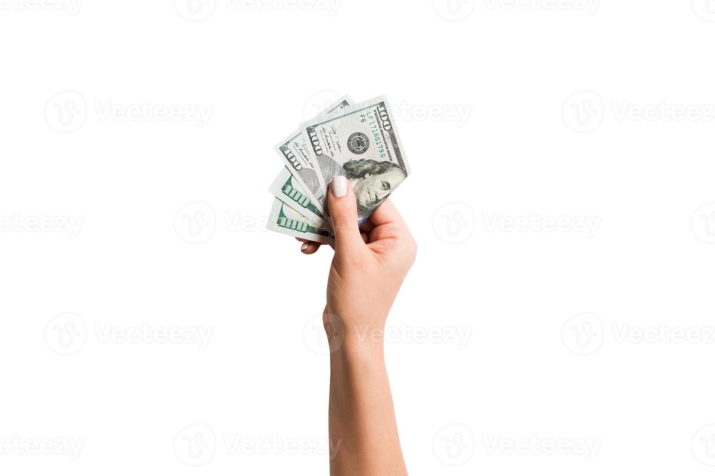 kvinna hand ger en bunt av dollar räkningar på vit isolerat bakgrund. topp se av kraft och rikedom begrepp foto