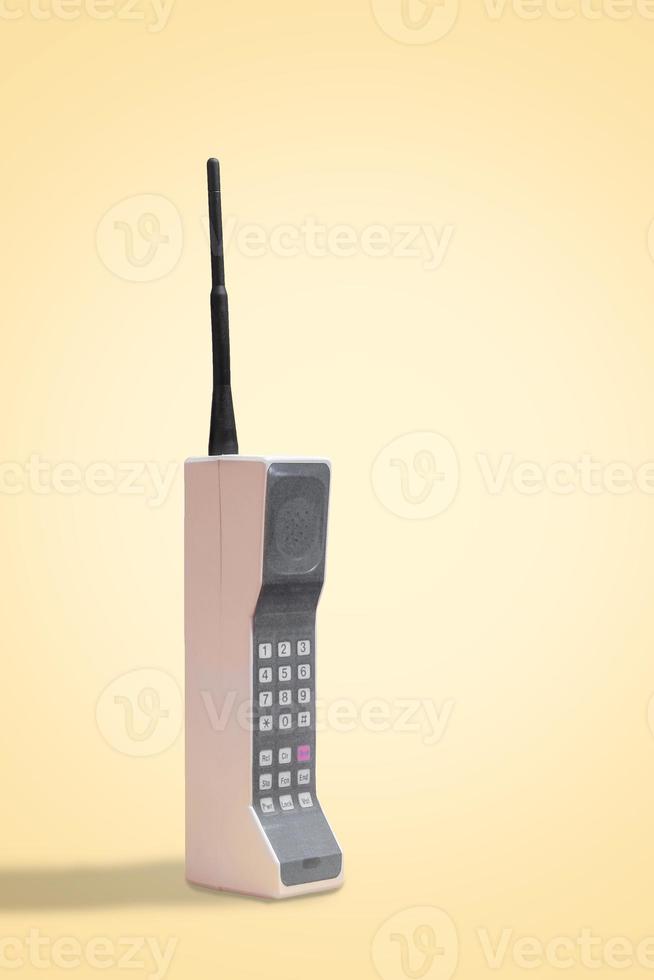 vintage 80-talets mobiltelefon på gul retro bakgrund med utrymme för kopia och text foto