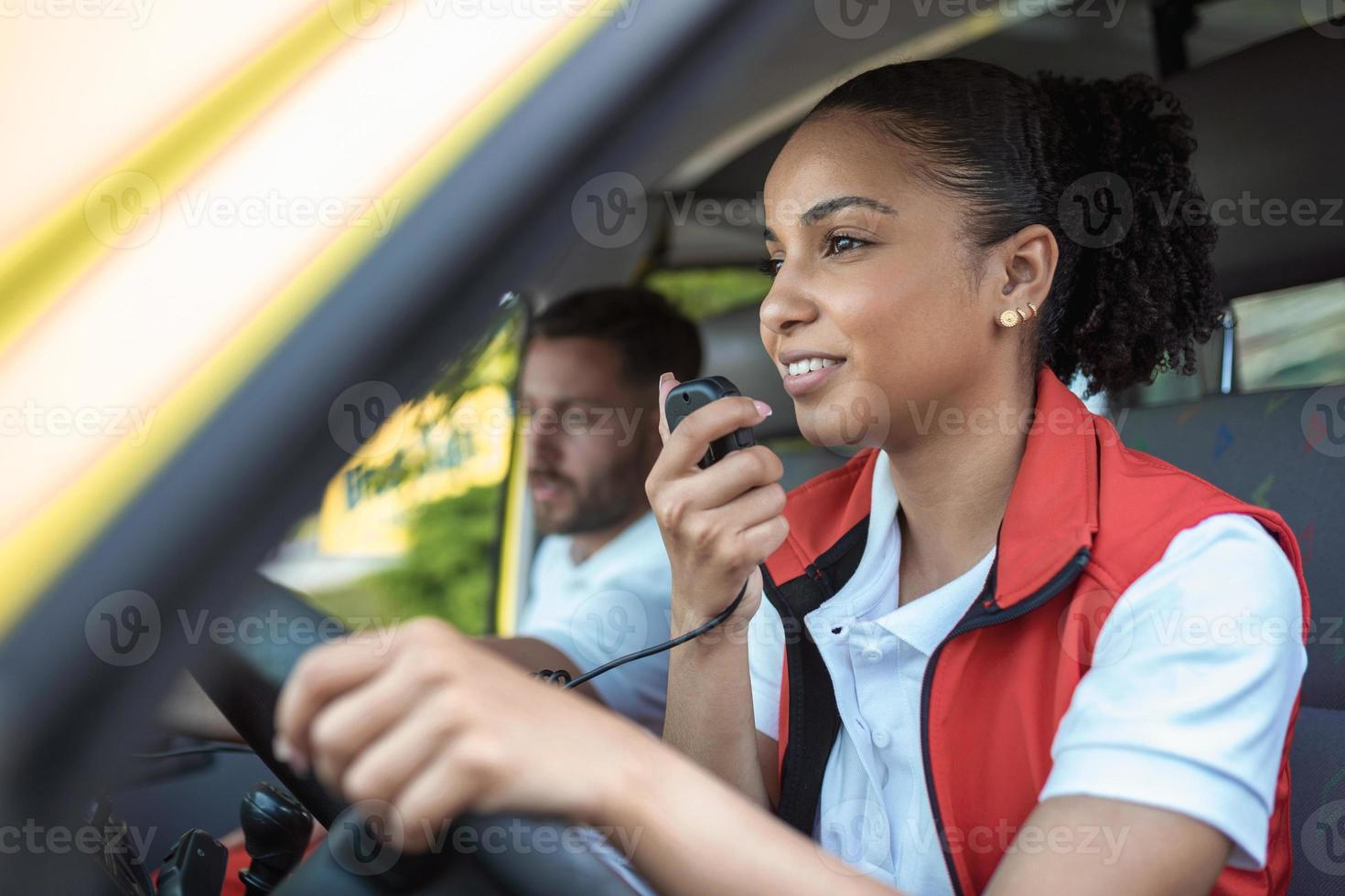 två paramedics i de ambulans. afrikansk amerikan kvinna para körning och talande över de radio foto