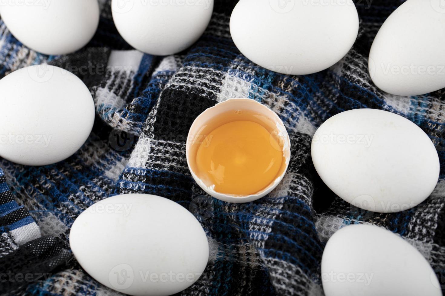 äggula och vita ägg på en randig trasa foto