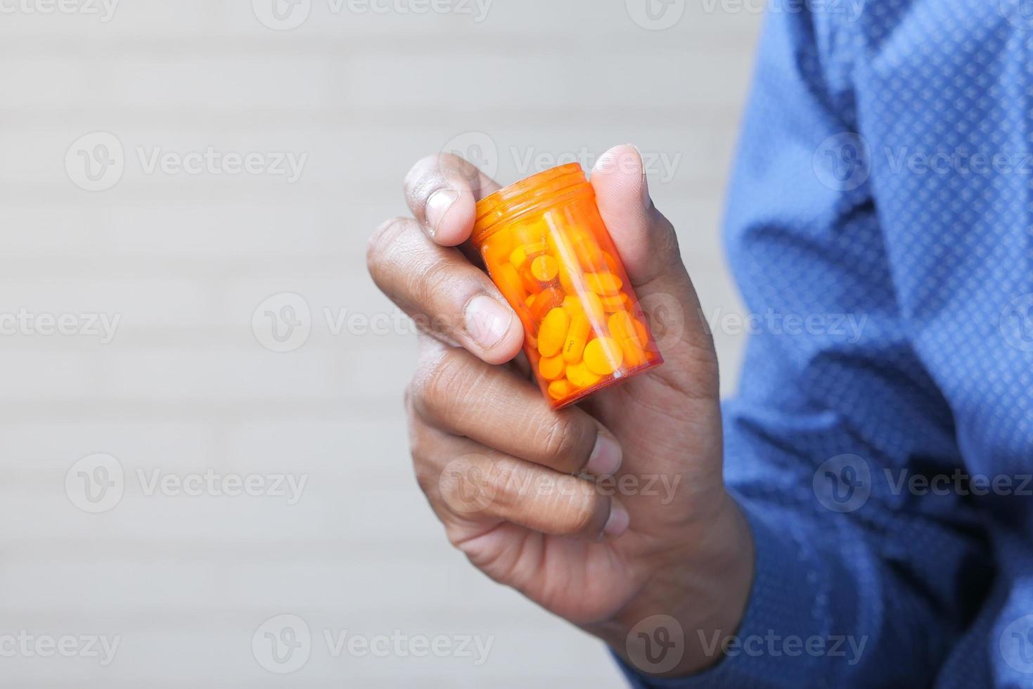 person handen håller piller behållare foto