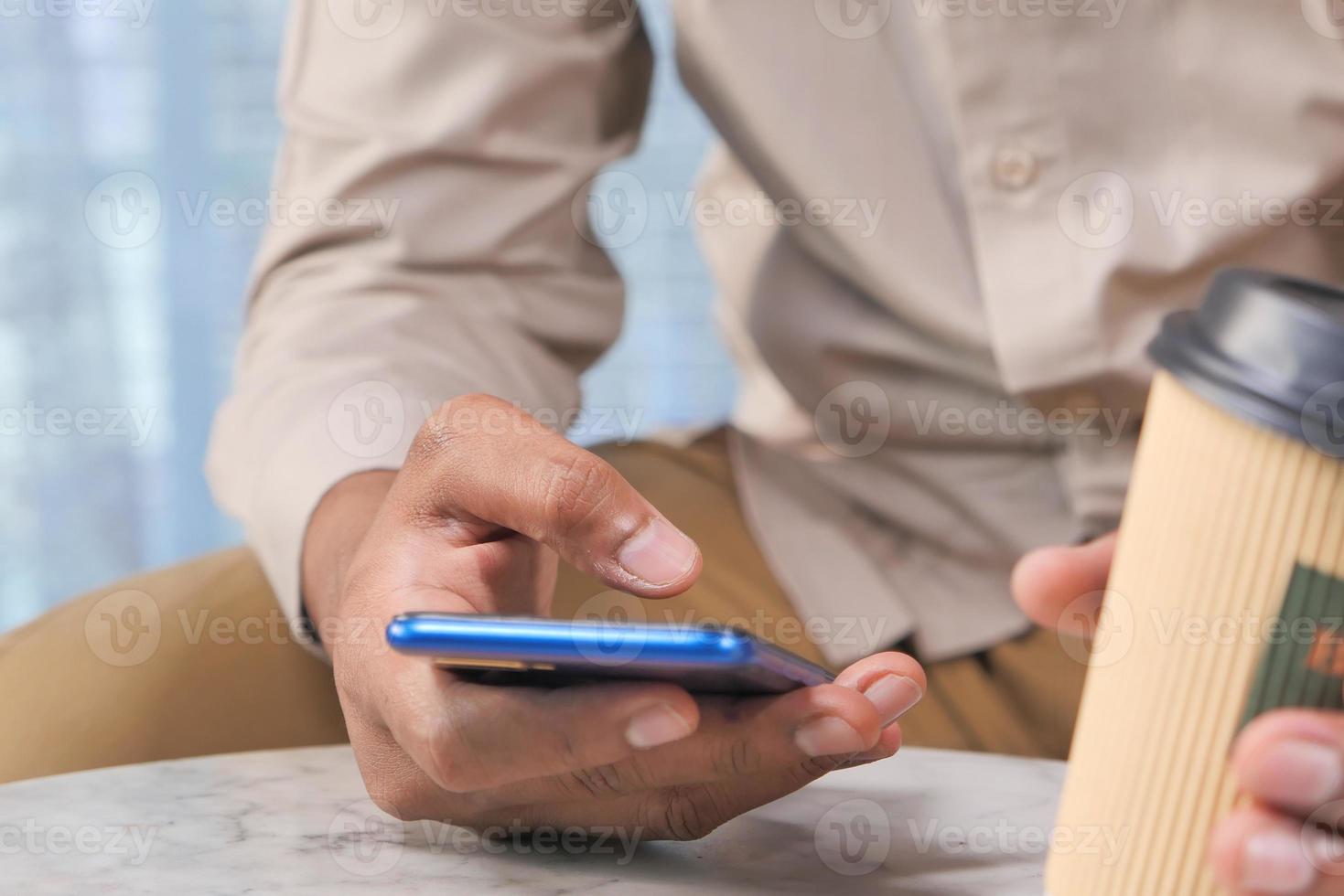 närbild av ung mans hand med smart telefon foto