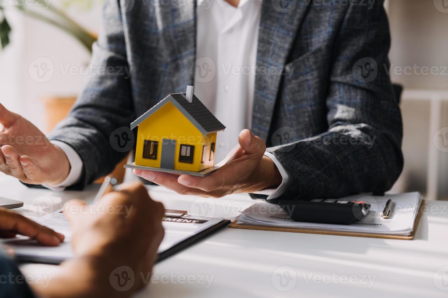 fastighetsmäklare presenterar och rådgör med kund till beslutsfattande teckna försäkringsformulär avtal, köp och sälj bostadsmodell, gällande bolåneerbjudande för och villaförsäkring foto