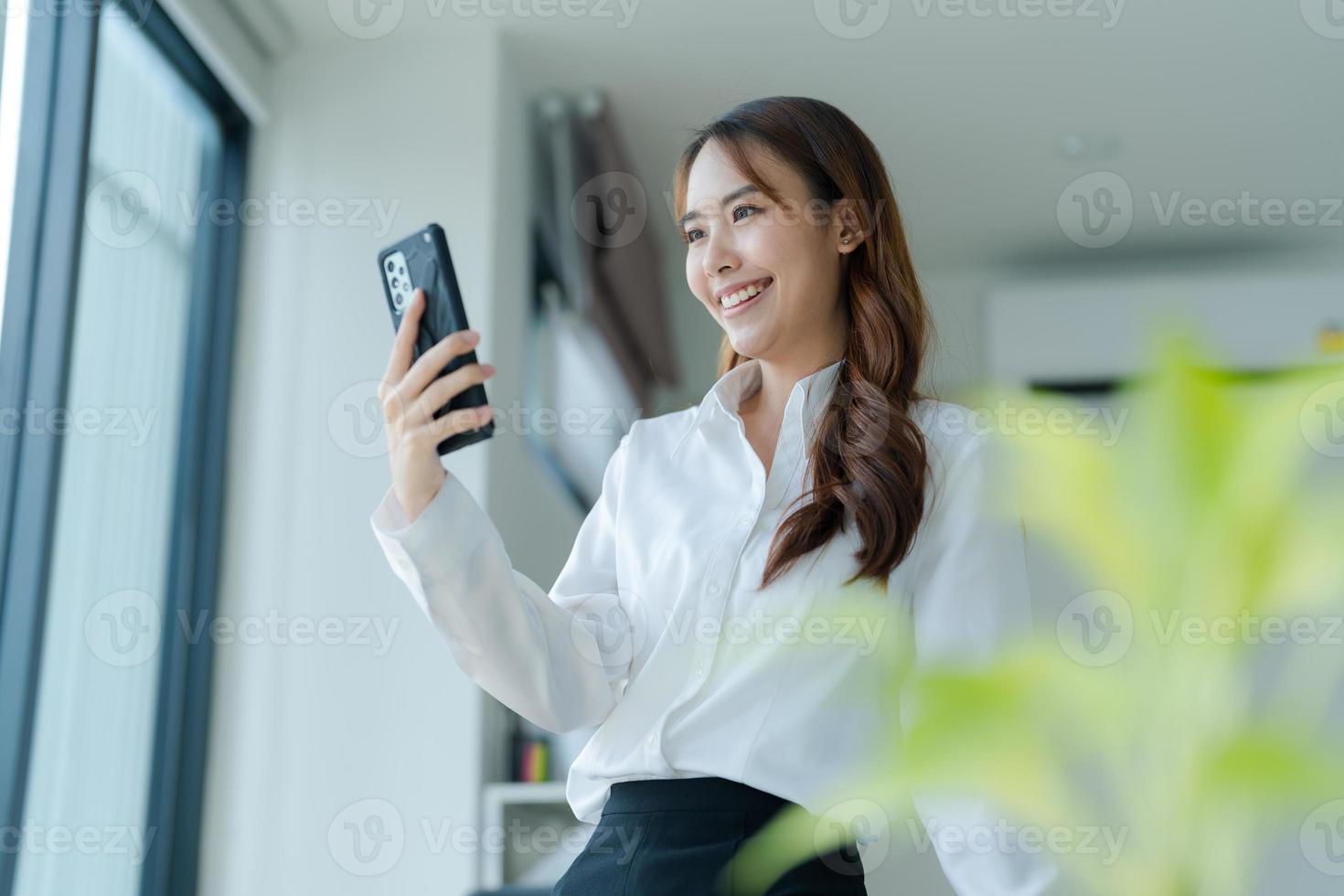Lycklig ung asiatisk företag kvinna bär kostym. foto