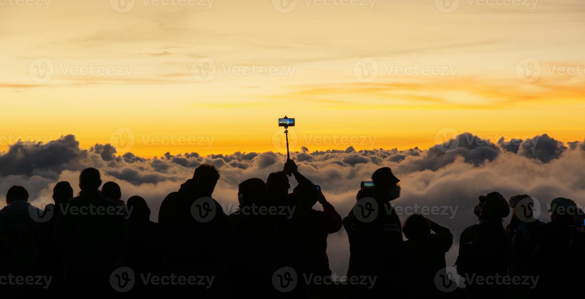 silhuett person grupp tittar på flytande hav av moln, hav av dimma, himmel ovan moln, tar clouds foton med mobil telefoner i de morgonsol stiga, resa lång helg, inhanon berg.