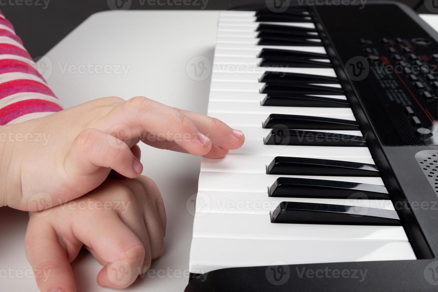 närbild av ett barn som spelar piano foto