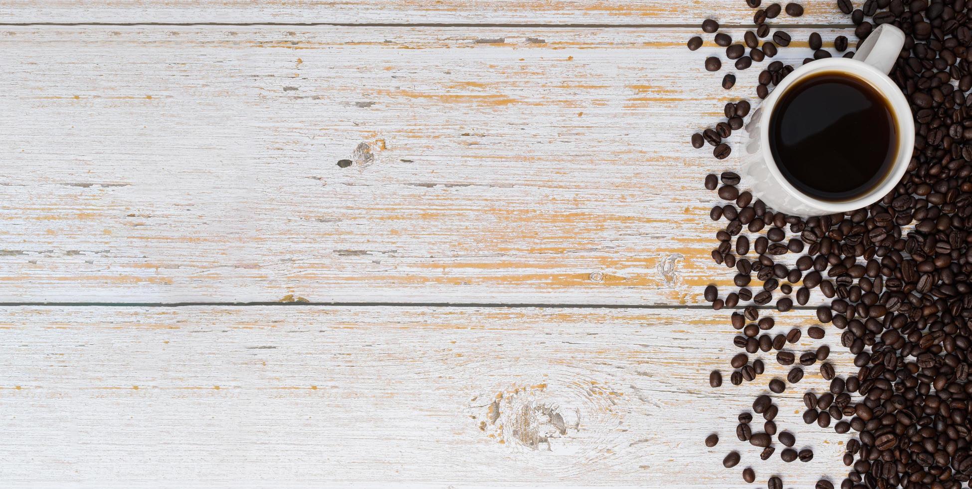 en kaffemugg och kaffebönor på ett träbord, älskar kaffekoncept foto