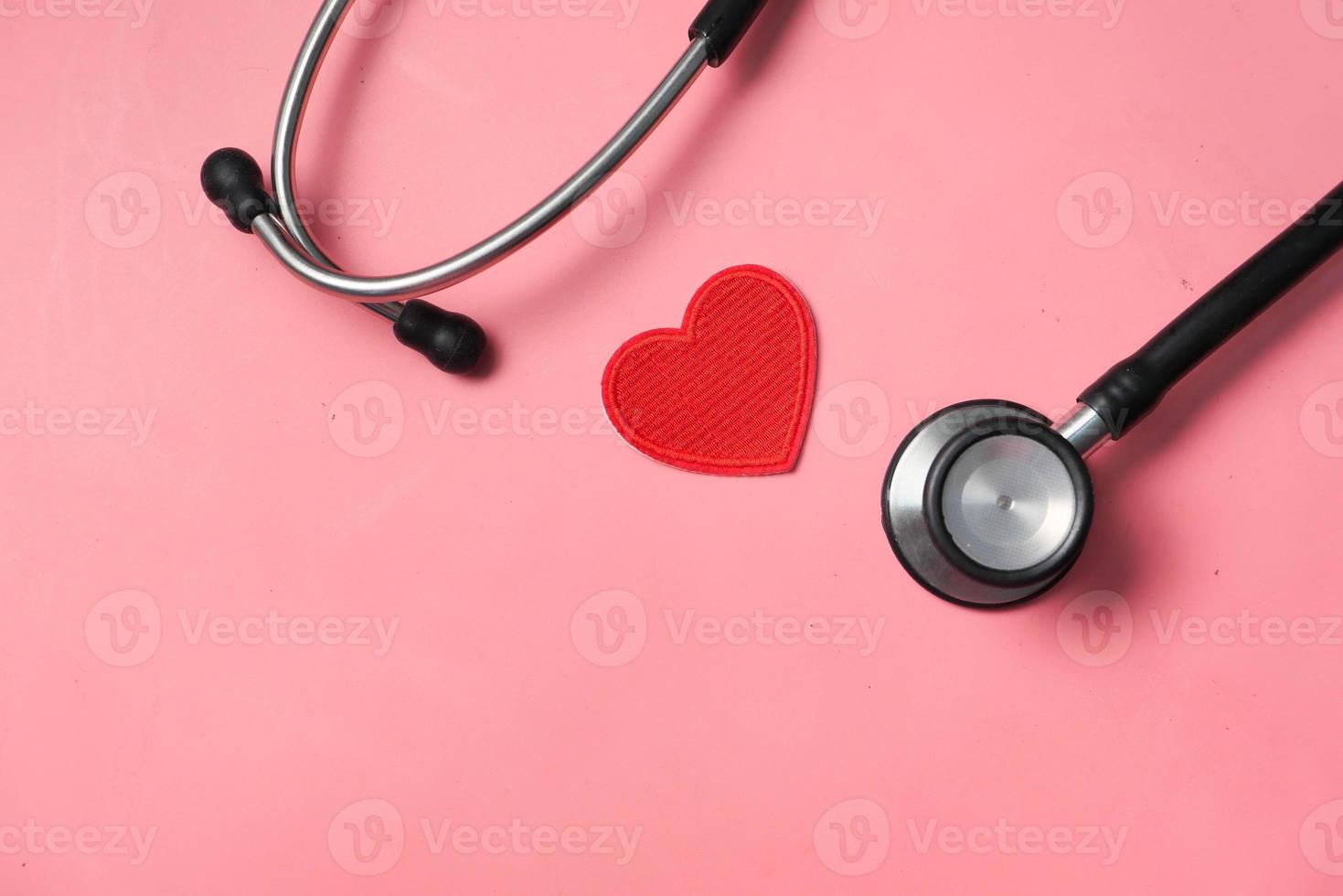 hjärtformad symbol och stetoskop på rosa bakgrund foto