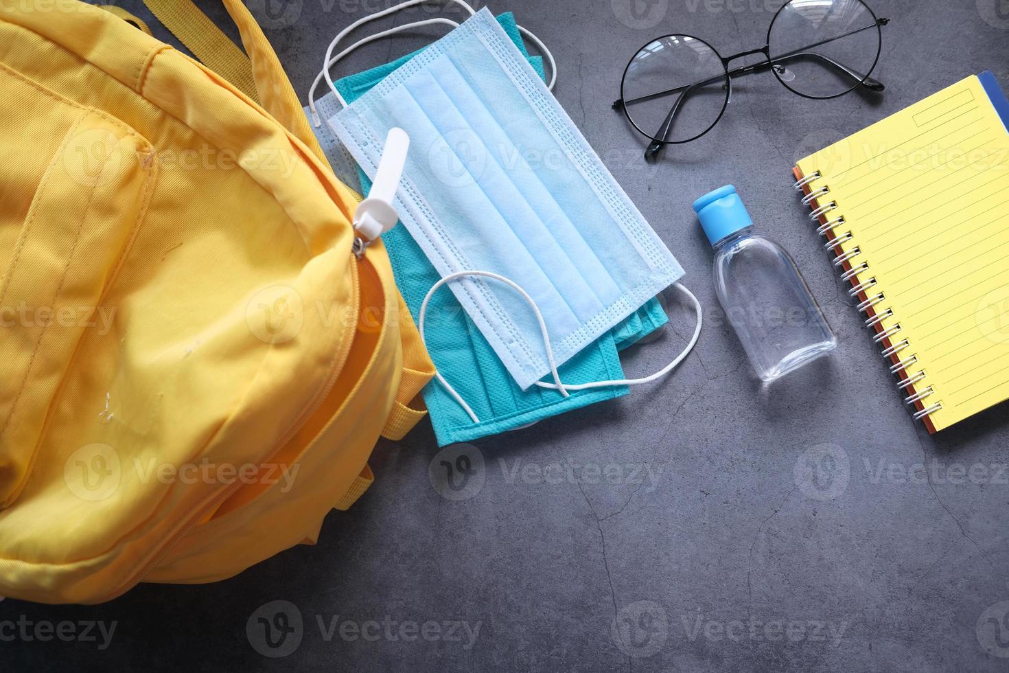 student skolväska packad med desinfektionsmedel och en ansiktsmask foto