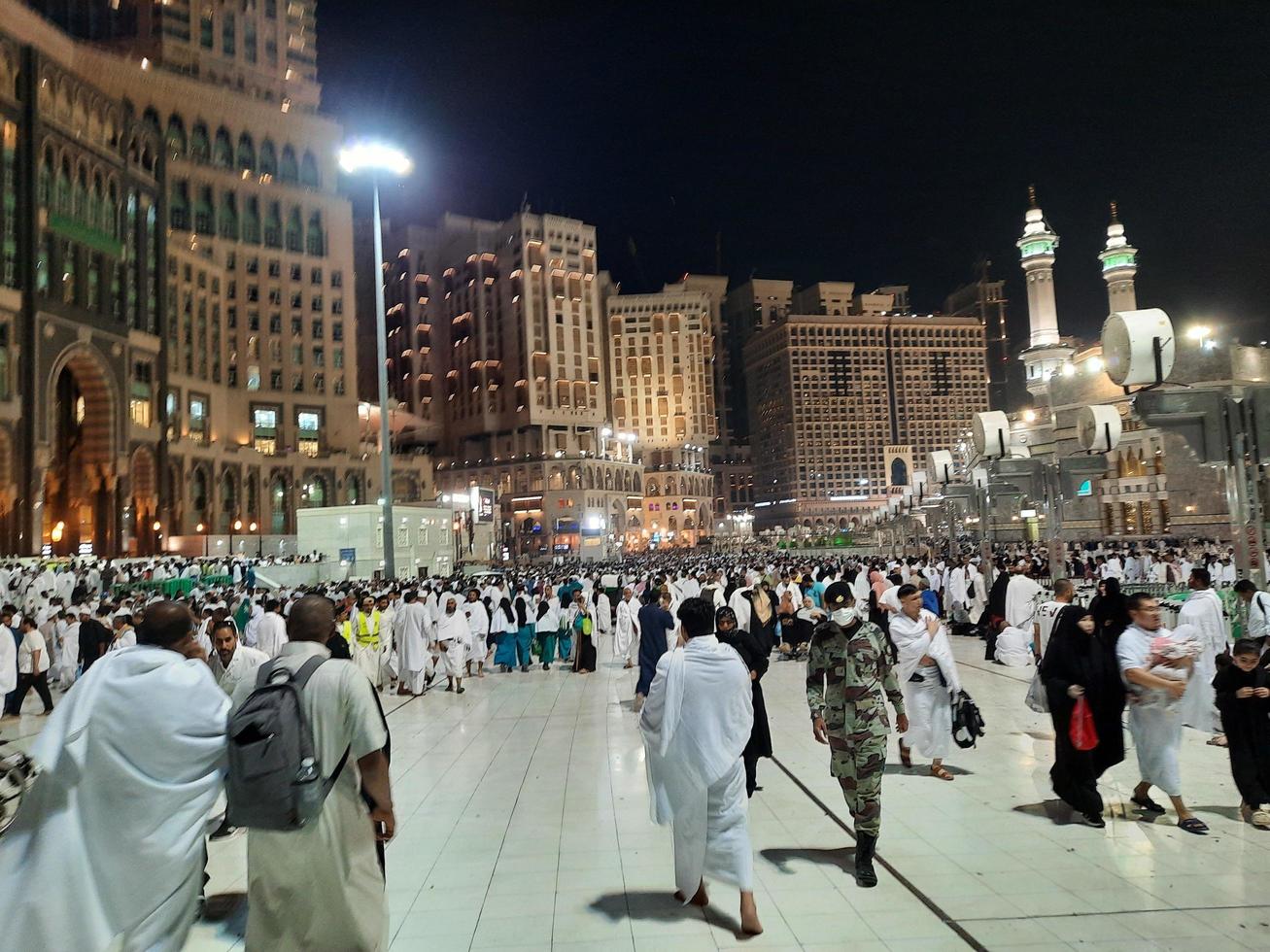 mecka, saudi Arabien, Mars 2023 - en stor siffra av umrah pilgrimer i främre av de klocka torn i masjid al haram. foto