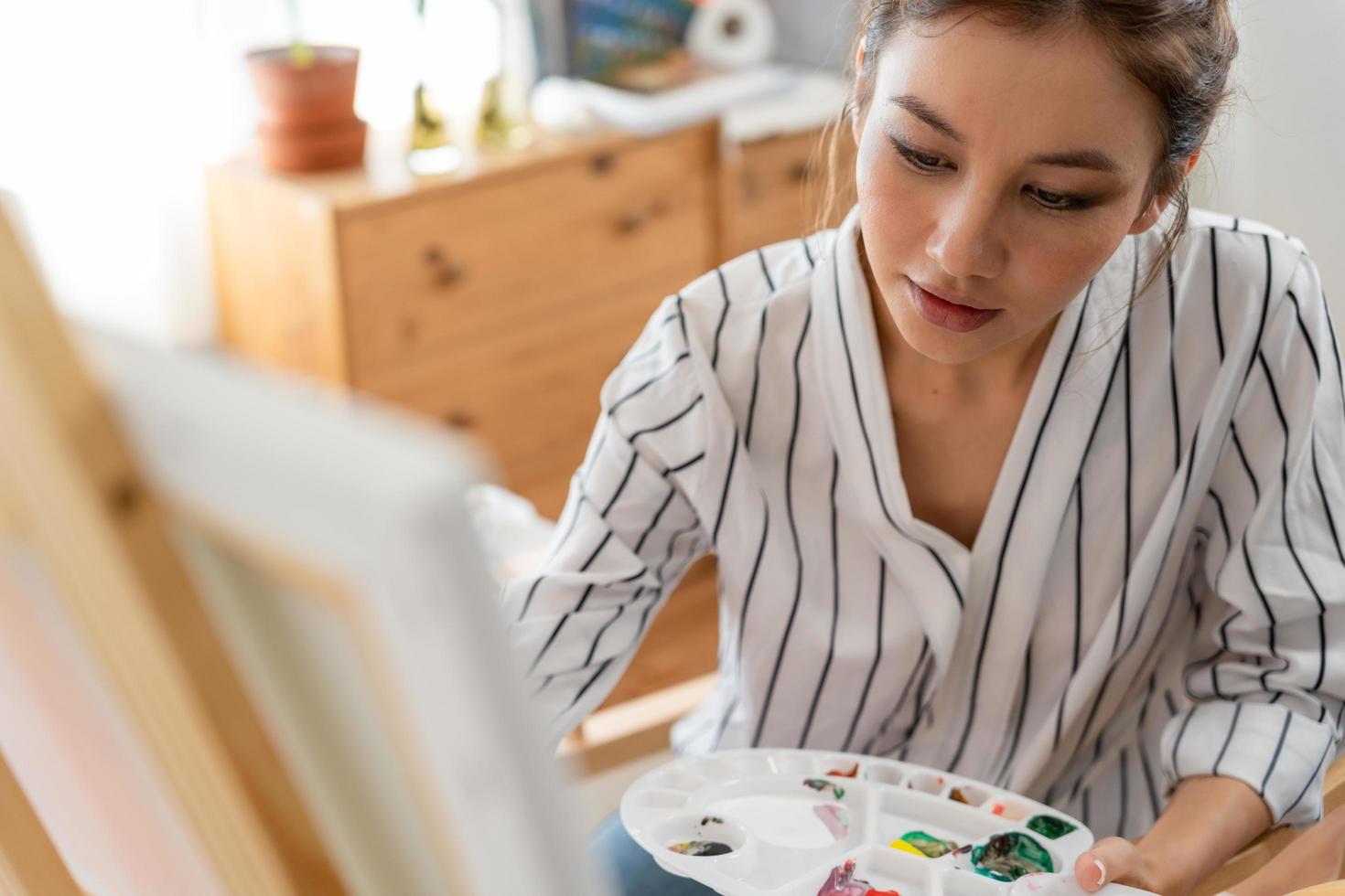 skön kvinna hobbies handla om konstnär och använda sig av paintbrush i abstrakt konst för skapa mästerverk. målare måla med akvareller eller olja i studio hus. njut av målning som hobby, rekreation, inspiration foto